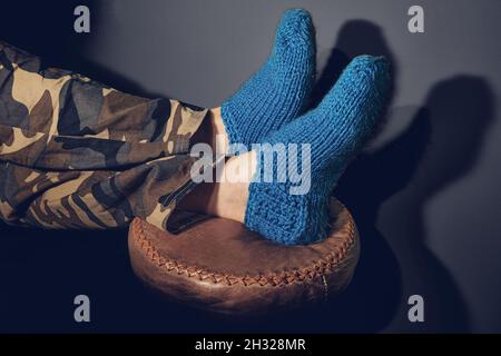 Uomo piedi in calze di lana su sgabello Foto Stock