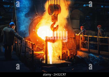 Processo di colata in fonderia, colata di metallo liquido fuso in siviera. Industria metallurgica pesante. Foto Stock