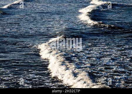 Primo piano di visione di onde bianche durante una marea in arrivo su una spiaggia Foto Stock