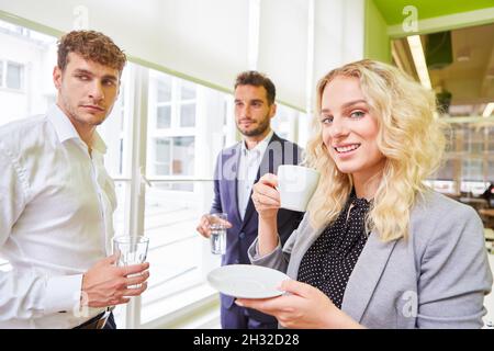 I giovani colleghi del team di start-up hanno un caffè durante una pausa in ufficio Foto Stock
