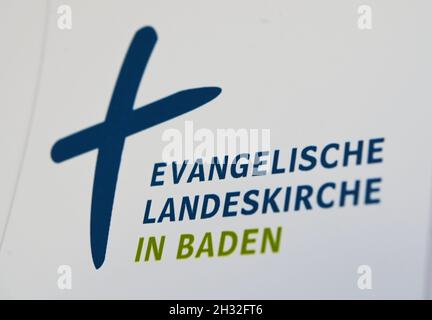 Bad Herrenalb, Germania. 25 ottobre 2021. Un logo della Chiesa regionale evangelica di Baden, preso in occasione dell'incontro autunnale del sinodo regionale della Chiesa regionale di Baden nel Kurhaus. I punti principali all'ordine del giorno sono l'adozione del doppio bilancio per gli anni 2022 e 2023, nonché le decisioni fondamentali nel quadro del processo di strategia regionale per la chiesa. Credit: Uli Deck/dpa/Alamy Live News Foto Stock