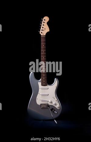 Chitarra elettrica argentata isolata su sfondo nero. Foto Stock
