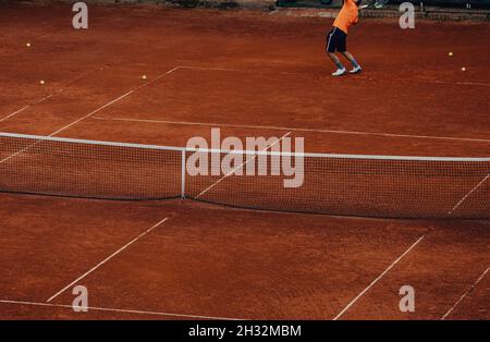 l'allenamento maschile dei giocatori di tennis serve sul campo da tennis Foto Stock