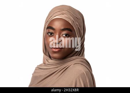 Ritratto di modesta donna musulmana nera in hijab guardando e posando la macchina fotografica, in piedi isolato su sfondo bianco studio, spazio vuoto. Bellezza Concep Foto Stock