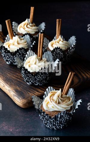 Cupcake fatti in casa di zucca spezia su un bordo di legno scuro con uno di fronte. Foto Stock