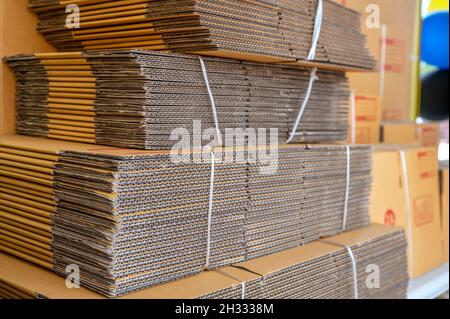 Pila di scatole di cartone piegate di colore marrone legate per l'imballaggio Foto Stock