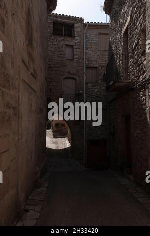 Strada di pietra con un arco nel borgo medievale di Guimerá nel nord della Spagna Foto Stock