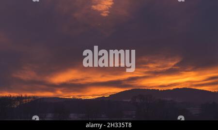 tramonto - cielo rosso sopra il paesaggio collinare Foto Stock