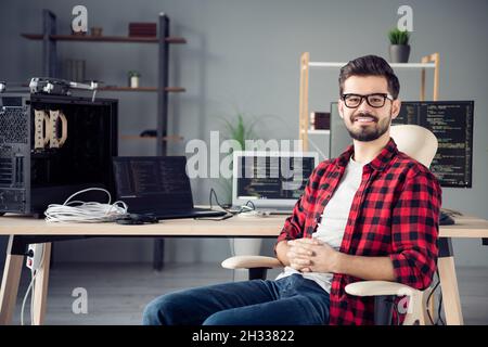 Ritratto di attraente ragazzo allegro hacker programmazione codice di sicurezza dati assistenza remota sul posto di lavoro stazione al chiuso Foto Stock