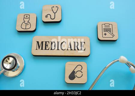Polsini di legno e piatto Medicare assicurazione con stetoscopio. Foto Stock