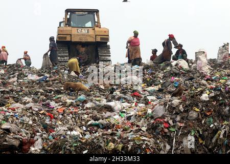 Persone raccolta rifiuti pick i rifiuti non biodegradabili da utilizzare per l'industria di riciclaggio in discarica sito a Dhaka molte persone vivono raccogliendo rifiuti dalle montagne di rifiuti che è generato quotidianamente, soprattutto dalla capitale di Dhaka. Il Bangladesh, l'ottavo paese più popoloso del mondo, ha attualmente un grave problema di inquinamento dovuto alla produzione di rifiuti solidi nelle aree urbane del Bangladesh, che equivale a circa 25,000 tonnellate al giorno. La città di Dhaka produce un quarto di tutti i rifiuti urbani del paese. Si prevede che i rifiuti solidi urbani totali aumentino fino a 47,000 tonnellate per Foto Stock