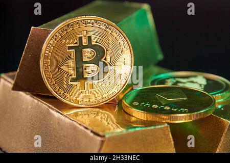 Monete di criptocurrenia sul mazzo di lingotti d'oro. Foto Stock