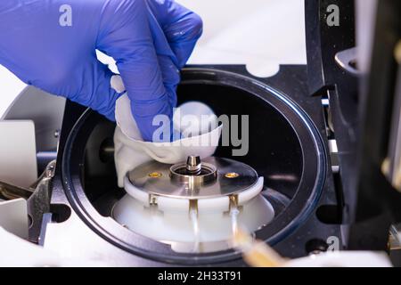 Pulizia della fonte di ioni dello spettrometro di massa da parte di un operatore di laboratorio con guanti di gomma. LC MS, cromatografia liquida e routine quotidiana Foto Stock