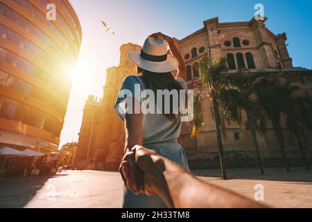 Seguimi. Donna turistica che guida il suo ragazzo a Malaga. Coppia in vacanza estiva in Spagna. Viaggia insieme. Foto Stock