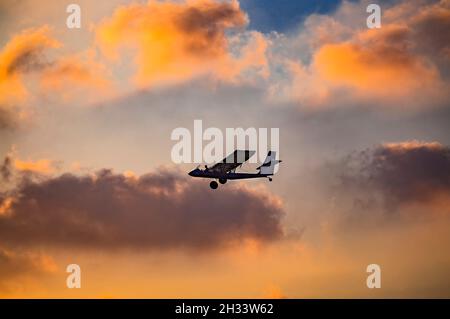 silhouette di ultraleggero microlite che vola con un pilota e un passeggero contro il cielo del tramonto. Foto Stock