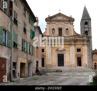 Il ciclista solitario sta riposando di fronte alla chiesa cattolica romana nella piazza abbandonata, Sospel, Francia. Foto Stock