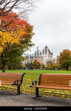 Ottawa, Canada - 14 ottobre 2021: Panchine nel Major's Hill Park e hotel Fairmont Chateau Laurier nel centro della città in autunno Foto Stock