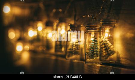 Decorazione di Natale ghirlanda elettrica con piccolo albero di Natale all'interno di luci dai toni caldi coperte sulla parete di legno. Umore di Natale ampio-aperto A. Foto Stock