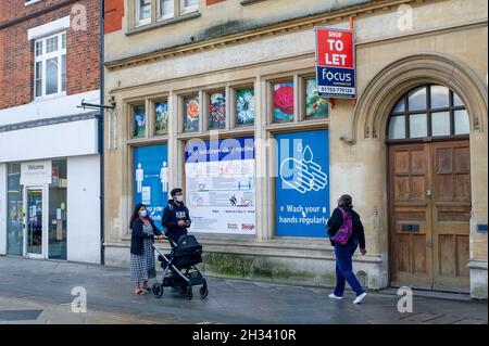 Slough, Berkshire, Regno Unito. 25 ottobre 2021. Gli acquirenti camminano oltre un Covid-19 Lavare le mani regolarmente segno in Slough High Street. Il numero di casi positivi di Covid-19 in Slough è salito a 480 da 419 per 100,000 persone nei sette giorni fino al 18 ottobre incluso rispetto alla settimana precedente. Credit: Maureen McLean/Alamy Live News Foto Stock