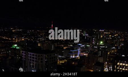 Vista dall'alto della città notturna con lampi di fuochi d'artificio. Riprese in stock. Città oscura con lampi di fuochi d'artificio multicolore in lontananza. Panorama della città notturna Foto Stock