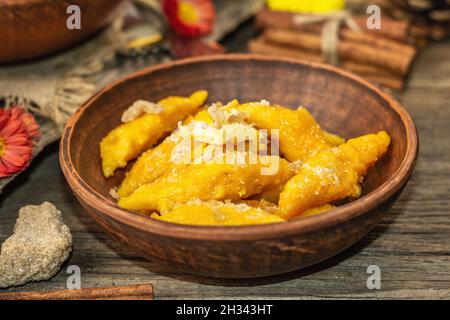 Gnocchi di zucca o gnocchi italiani. Piatto di squash vegetariano sano con formaggio caserario. Decorazioni autunnali con foglie autunnali, zucche intere, fiori e s. Foto Stock