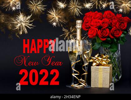 Felice anno nuovo 2022. Rose rosse, bottiglia di champagne, confezione regalo dorata Foto Stock