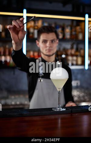 il barman sta facendo un cocktail con una bolla d'aria fumosa Foto Stock