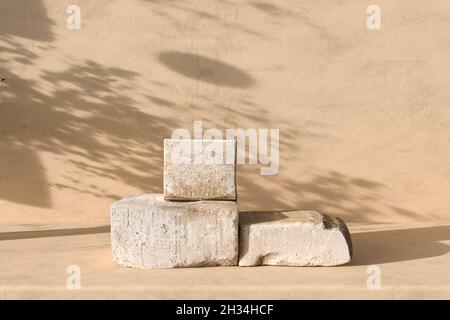 Podio in pietra beige. Piattaforma per la presentazione cosmetica del marchio del prodotto. Scena con ombra di sfondo. illustrazione del rendering 3d. Foto Stock