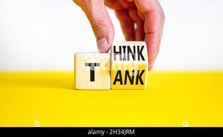 Think Tank. L'uomo d'affari trasforma un cubo di legno e cambia la parola 'serbatoio' in 'pensare' o viceversa. Bella tabella gialla, sfondo bianco, poliziotto Foto Stock