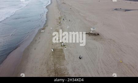 Huntington Beach, Stati Uniti. 04 Ottobre 2021. Gli equipaggi di contenimento di emergenza iniziano a ripulire la spiaggia a seguito di una fuoriuscita di petrolio in mare aperto a San Pedro Bay 4 ottobre 2021 a Huntington Beach, California. Si stima che 144,000 galloni fuoriusciti da un gasdotto al largo della costa della contea di Orange il 1° ottobre. Credito: PO1 Richard Brahm/Stati Uniti Coast Guard/Alamy Live News Foto Stock