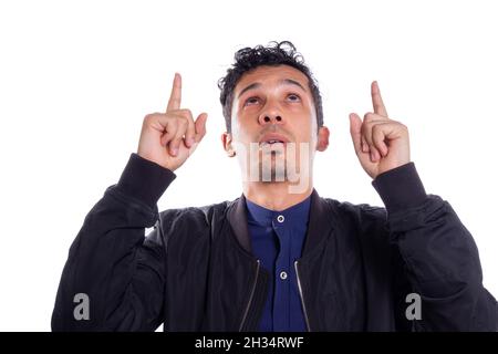 Uomo che punta con entrambe le mani, sfondo bianco. Giovane adulto Latino giovane uomo in cerca. Foto Stock