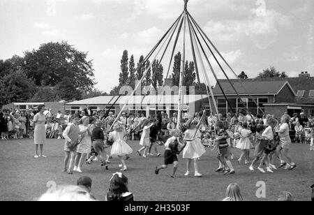 1965 - i bambini della scuola primaria ballano intorno ad un palo di maggio durante il fete della scuola al più basso Pover, Cheshire Foto Stock