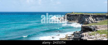 Punta sur - punto più a sud di Isla Mujeres, Messico. Spiaggia con rocce sul mare dei Caraibi Foto Stock