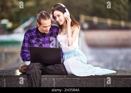 In coppia con il computer portatile e le cuffie senza fili potrai guardare i film nel parco. Foto Stock