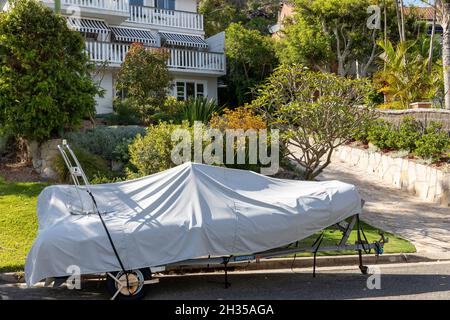 Barca su un rimorchio con copertura all'esterno di una casa di Sydney a Avalon Beach, nuovo Galles del Sud, Australia Foto Stock
