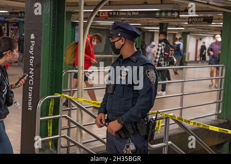 NEW YORK, NY – 25 OTTOBRE: Gli ufficiali del New York Police Department (NYPD) dirigono i passeggeri lontano dalla scena criminale alla stazione metropolitana di Union Square il 25 ottobre 2021 a New York City. Un uomo è stato girato in gamba durante il tentativo di rapina per il telefono cellulare sul treno N nord come si è avvicinato alla stazione di Union Square poco prima delle 17:00. L'uomo di 42 anni, secondo NYPD, è stato girato perché non ha agito abbastanza veloce. La vittima è stata portata a Bellevue in condizioni stabili. Il sospetto come lui fuggito il treno e la stazione. Foto Stock