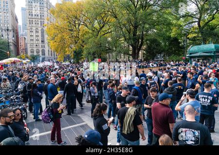 New York, NY - 25 ottobre 2021: I lavoratori municipali della città marciano attraverso il ponte di Brooklyn e si radunano al City Hall Park contro il mandato di vaccinazione Foto Stock