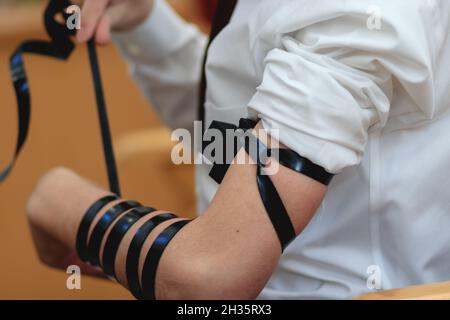 gerusalemme-israele. 24-01-2020. Un primo piano di un ragazzo di bar mitzvah ebraico, indossando una camicia bianca, ha messo il tefillin per la prima volta in una sinagoga Foto Stock