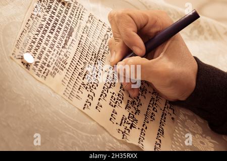 La mano di un produttore, pratica decorare le lettere da un rotolo di Torah scritto su pergamena in ebraico, (per l'editore - le lettere ebraiche sono casuali - wi Foto Stock