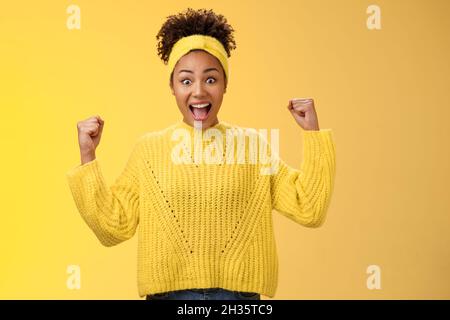 Sì, infine, il mio premio. Eccitato sorpreso divertito ragazza afroamericana che celebra la vittoria acifement sorridendo sorridendo ampiamente yelling fisti di riposo Foto Stock