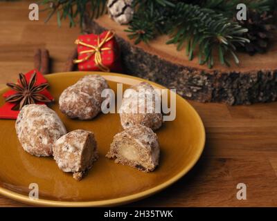 Delizioso stollen di Natale su un piatto di ceramica di fronte a una corona di Avvento e decorazioni natalizie, cibo di stagione Foto Stock