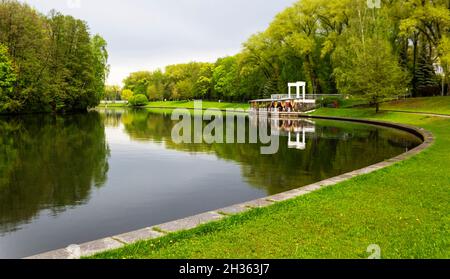 curva del fiume nel parco della città in primavera con il bel tempo. Cafe sulla riva del fiume Foto Stock