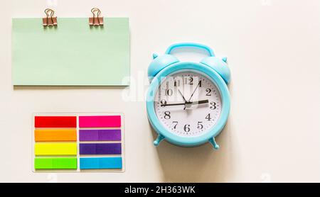 Sveglia con nota vuota e adesivi colorati su sfondo bianco. Foto Stock