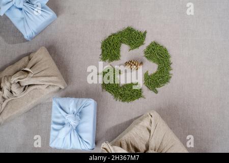 Riutilizzando i vestiti per avvolgere i regali. Confezioni confezionate in plastica. Stile di vita senza sprechi. Vista dall'alto o disposizione piatta. Foto Stock