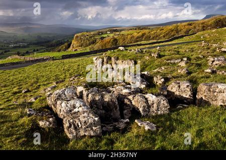 Vista autunnale dopo la pioggia. Winskill Stones sopra Langcliffe, Ribblesdale, Yorkshire Dales National Park. Rocce calcaree marciate in primo piano. Foto Stock