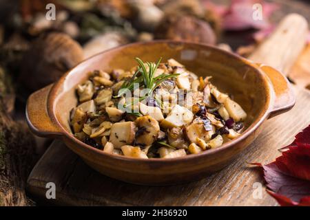 Funghi di foresta fritti, porcini, cipolle. Piatto rustico in padella, piatto autunnale vegetariano in vista Foto Stock