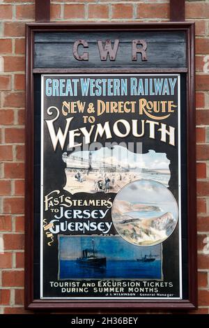 Replica Great Western Railway pubblicità poster dai primi del 1900 's pubblicità di un nuovo percorso a Weymouth. Foto Stock