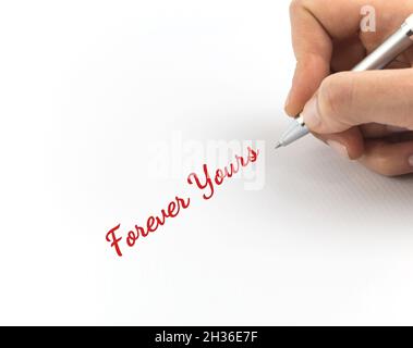 Scrittura a mano 'Forever Yours' su foglio bianco di carta. Foto Stock