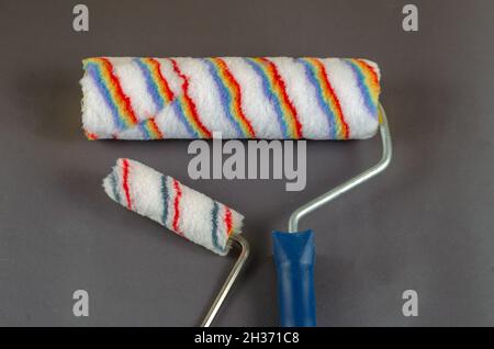 Due rulli di vernice su sfondo grigio. Set di utensili manuali per la verniciatura di pareti, soffitti, mobili e altre superfici. Servizi di verniciatura. Messa a fuoco selettiva Foto Stock