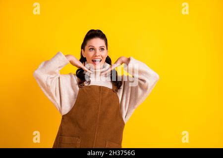 Ritratto di attraente ragazza sognante allegra posa divertirsi godendo di buon umore isolato su sfondo giallo chiaro Foto Stock